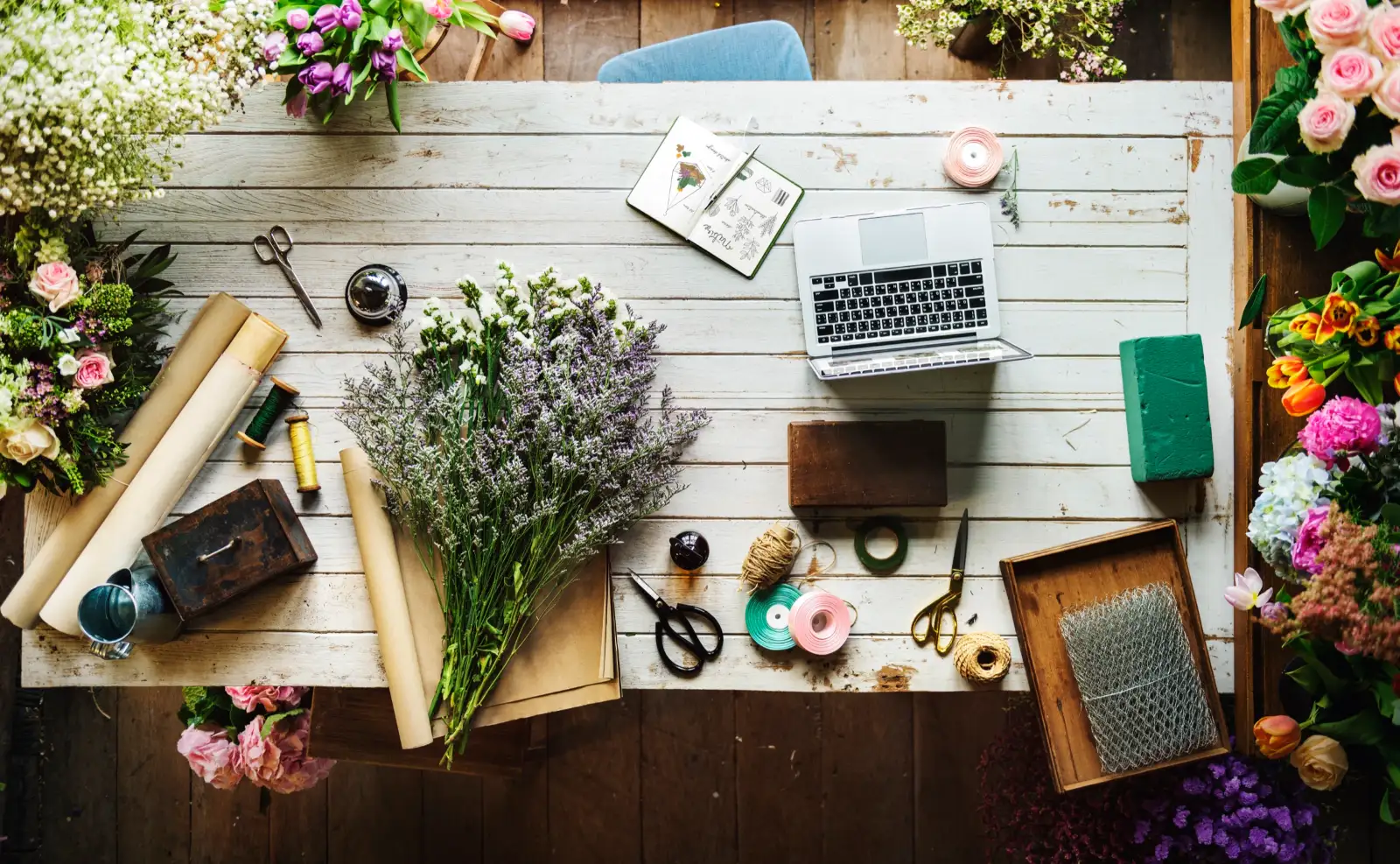 A white work table with lavender, wrapping paper, twine and scissors